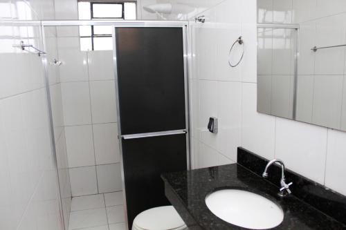 a bathroom with a shower and a toilet and a sink at Residence Hotel Ltda in Paiçandu