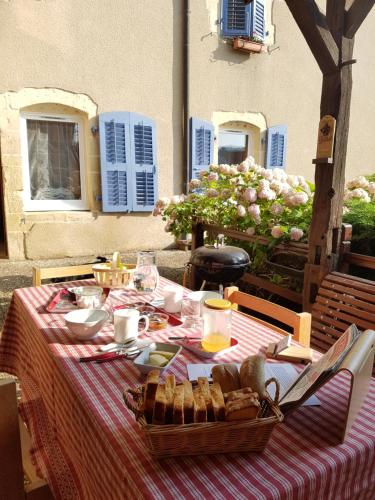 una mesa con un mantel de rayas rojas y blancas en La Grange Des Roches Roses, en Anchenoncourt-et-Chazel