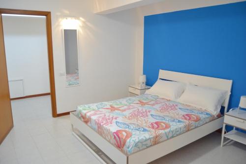 Un dormitorio con una cama con una pared azul. en Casa DahLia Mondello, en Mondello