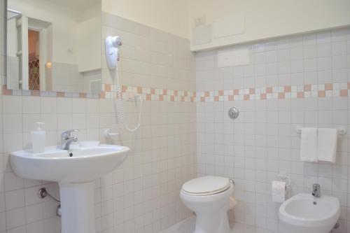 Un baño blanco con lavabo e inodoro. en Casa DahLia Mondello, en Mondello