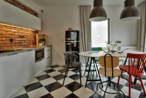a kitchen with a checkered floor and a table and chairs at KOMFORTOWE DOMKI Brzozowa Przystań nad morzem we Władysławowie in Władysławowo