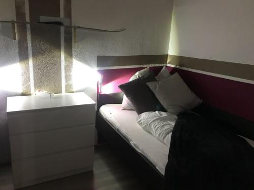 a bedroom with a bed with a nightstand and avertisement at Hahnenklee Ferienpark 1-411 in Hahnenklee-Bockswiese