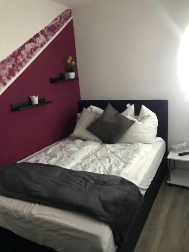 a bedroom with a bed with a purple accent wall at Hahnenklee Ferienpark 1-411 in Hahnenklee-Bockswiese