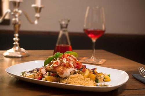 a plate of food on a table with a glass of wine at Zum Scheffelhof in Maulbronn