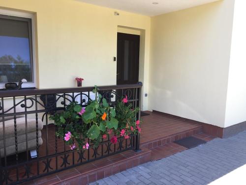 a balcony with a plant with flowers on it at Vila Laurus in Palanga