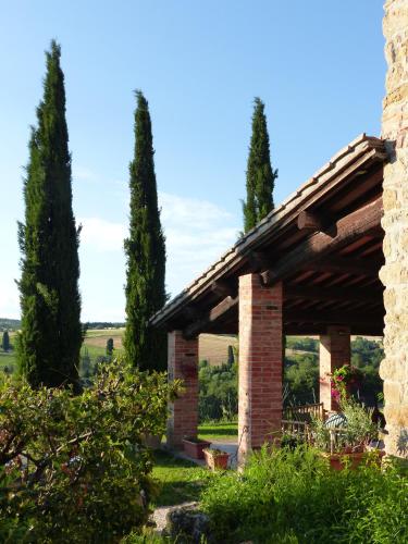 a stone pavilion with cypress trees in the background at Podere Cacchini in Pienza