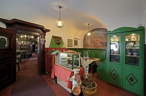 a shop with green cabinets and a table in a room at Hotel Zelený Dům in Boží Dar