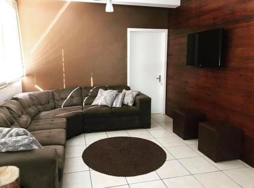 a living room with a couch and a flat screen tv at Hotel Guaporé - Campo Bom RS in Campo Bom
