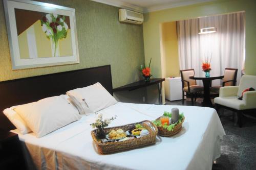 巴西利亞的住宿－堪丹戈埃羅酒店，酒店客房,配有一张床铺,上面有一篮子食物