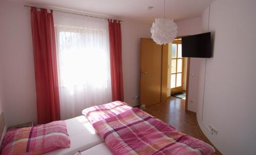 Una habitación con una cama con una manta. en Ferienwohnung Wagner Bayreuth en Bayreuth