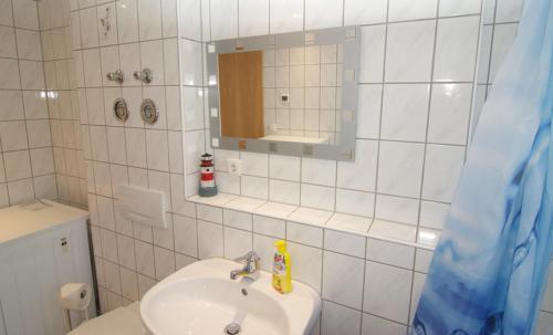 Baño blanco con lavabo y espejo en Ferienwohnung Wagner Bayreuth, en Bayreuth