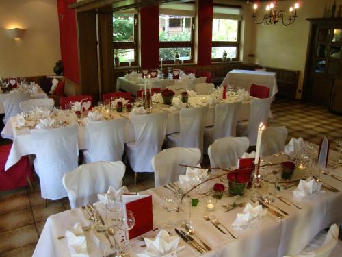 a room with white tables and chairs with white table cloth at Hotel Restaurant Paradeismühle in Klingenberg am Main