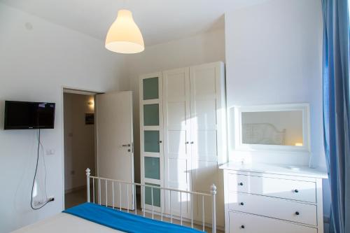 Habitación con armario blanco y espejo. en Jazira en Scoglitti
