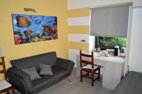 ein Wohnzimmer mit einem Sofa und einem Schreibtisch in der Unterkunft Relax nel Centro Storico in San Nicola Arcella