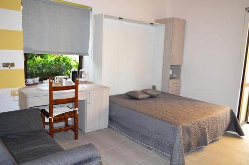 Schlafzimmer mit einem Bett, einem Schreibtisch und einem Stuhl in der Unterkunft Relax nel Centro Storico in San Nicola Arcella