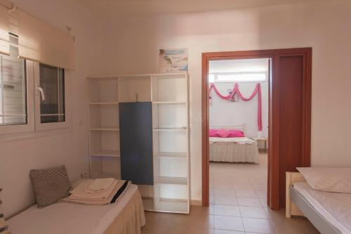 a room with two beds and a door to a bedroom at Kalliopi Apartments in Egina