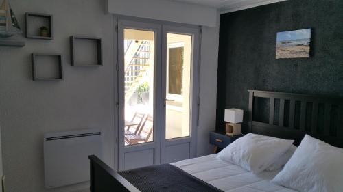 レ・サ​​ーブル・ドロンヌにあるLa Chaumetteのベッドルーム1室(ベッド1台付)、スライド式ガラスドアが備わります。