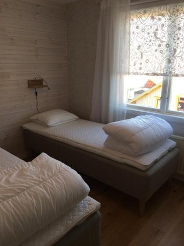 two twin beds in a room with a window at Mittes Rum in Alingsås