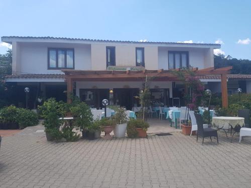 a building with a patio with tables and chairs at Casa vacanza Gigi e Antonella in Porto Rotondo