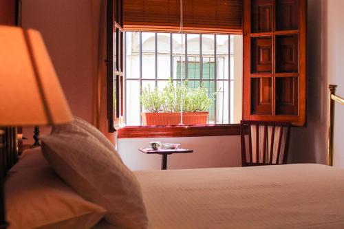 1 dormitorio con 1 cama y ventana con mesa en Casa rural Llana 12, en Guadalupe