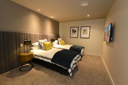 a bedroom with a large bed with yellow pillows at Distinction Dunedin Hotel in Dunedin