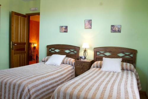 En eller flere senge i et værelse på Hotel Rural La Veleta
