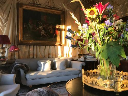 a living room with a couch and a vase of flowers at Park Mansion Centre in Amsterdam