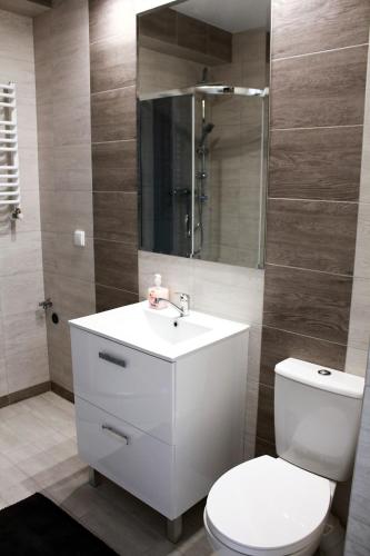 a bathroom with a white sink and a toilet at Apartamenty Mazury in Mrągowo