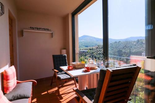a room with a table and chairs and a large window at Casa rural Llana 12 in Guadalupe