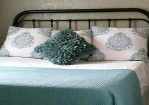 a bed with two pillows and a headboard at Secret Cottage Yellowstone 1 bd 2 beds dtwn #1 in Cody