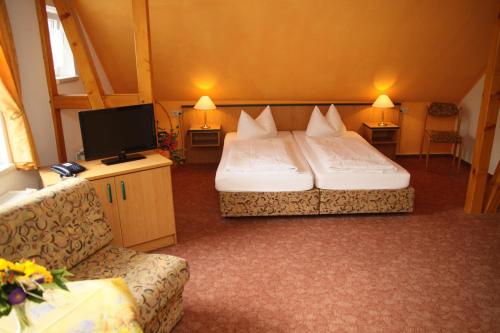 a hotel room with two beds and a tv at Haus Kehrwieder - Hotel am Kur-Café in Bad Suderode
