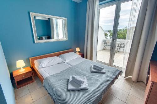 a bedroom with a bed with a mirror and a balcony at B&B Galija in Crikvenica