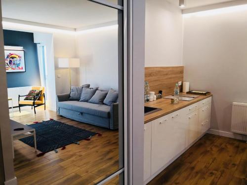 cocina y sala de estar con sofá azul en Piper Zajezdnia White en Poznan