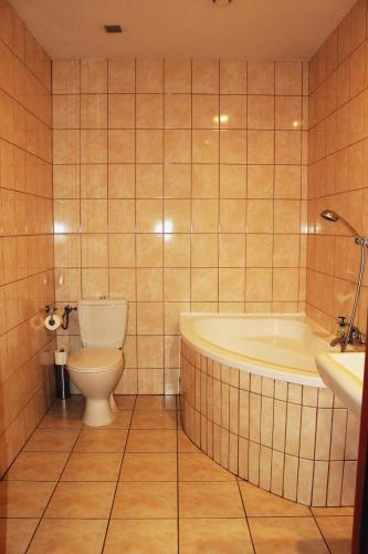 a bathroom with a tub and a toilet and a sink at Stacja Grand in Szczecin