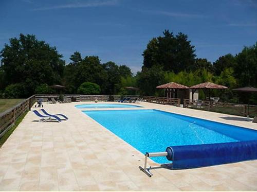 una gran piscina azul con sillas alrededor en Chateau d'Hordosse, en Andiran