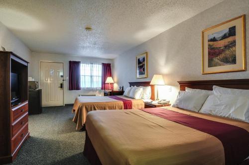 a hotel room with two beds and a flat screen tv at Americas Best Value Inn Midlothian in Midlothian