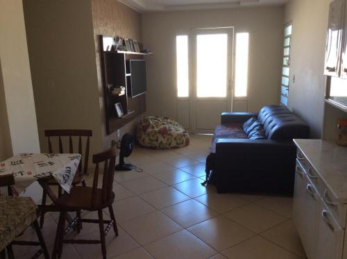 ein Wohnzimmer mit einem Sofa und einem Tisch in der Unterkunft Casa da Jussara in Itaperuna
