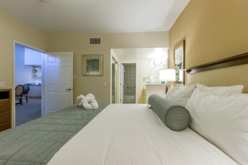 a large white bed with a stuffed animal sitting on it at Grand Pacific Palisades Resort in Carlsbad
