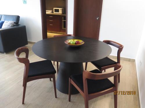 a table and chairs with a bowl of fruit on it at Tamarindo Centro Vip Apartment in San Andrés