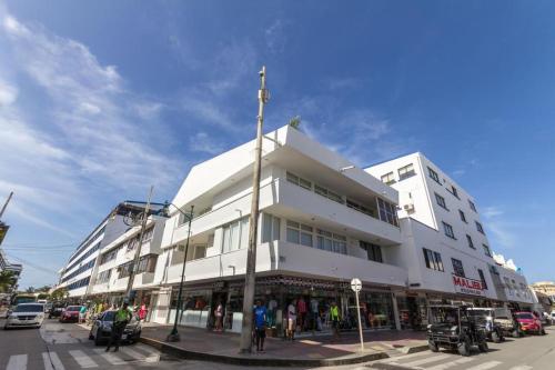a white building on the corner of a street at Tamarindo Centro Vip Apartment in San Andrés