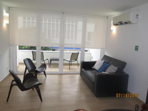a living room with a black couch and chairs at Tamarindo Centro Vip Apartment in San Andrés