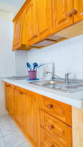 a kitchen with wooden cabinets and a sink at Apartamento Positive in Tamaduste