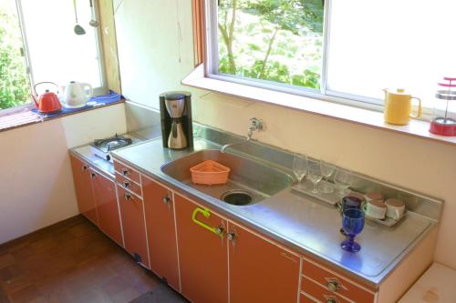 a kitchen with a sink and a window at Hutte Lied in Komoro