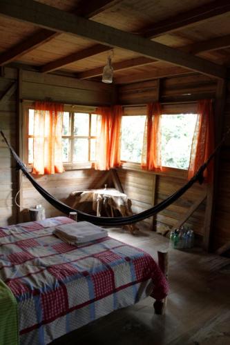 a bedroom with a hammock in a room with windows at Paraiso Verde in Chijoú