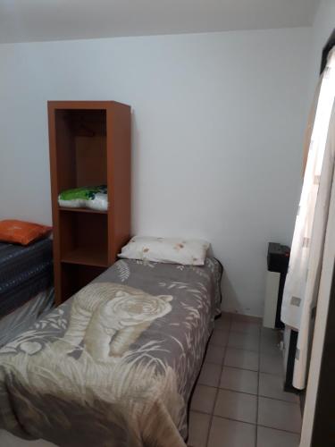 a small bedroom with a bed and a cabinet at Departamento ideal I! in Villa María