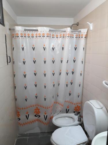 a bathroom with a toilet and a shower curtain at Departamento ideal I! in Villa María