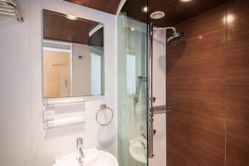 a bathroom with a glass shower and a sink at the b ikebukuro in Tokyo