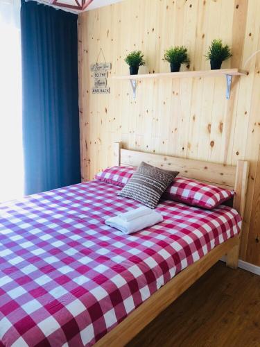 a bed with a red and white checkered blanket at Summit guest house in Ulaanbaatar