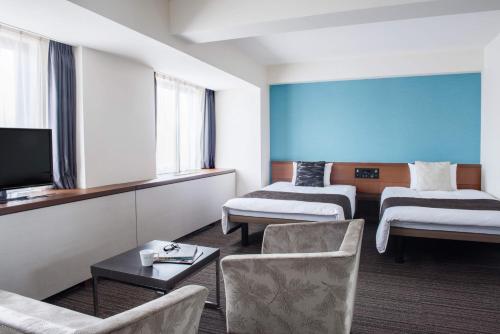 a hotel room with two beds and a flat screen tv at the b hachioji in Hachioji