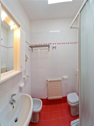 a bathroom with a sink and a toilet at Villaggio Mare Blu in Bibione